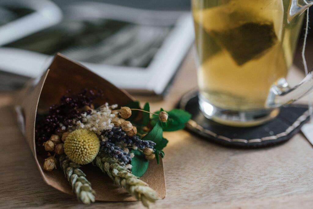 A delicate bouquet of dried flowers next to a warm cup of herbal tea, creating a cozy atmosphere.