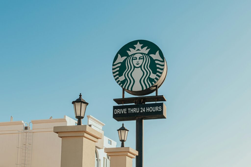 Starbucks drive thru sign in Dubai under a clear blue sky, showcasing the iconic logo.