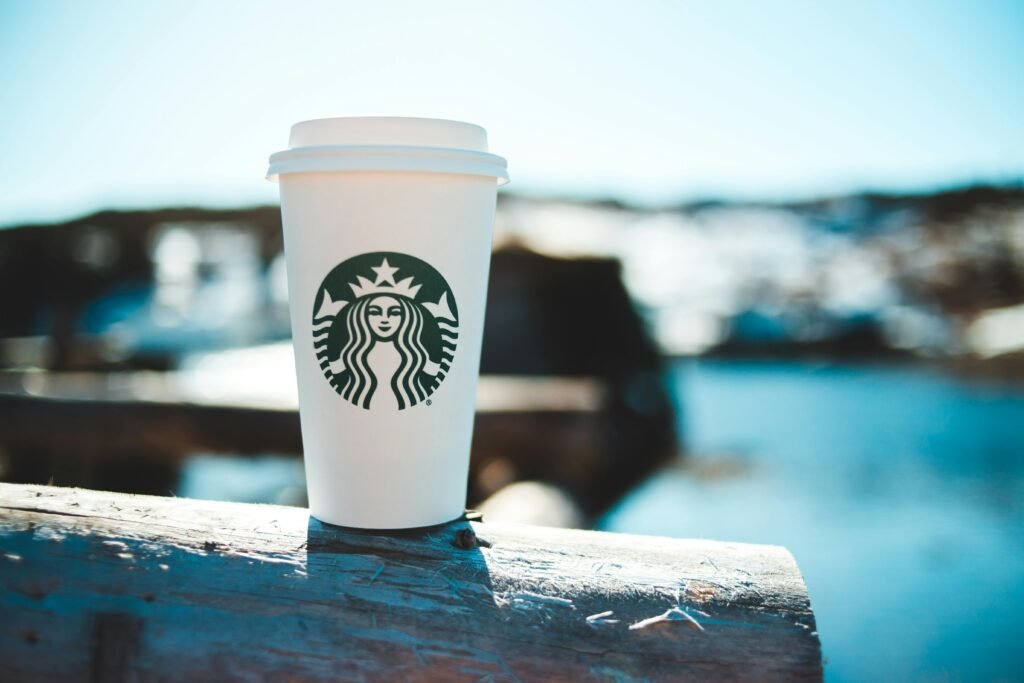 A disposable coffee cup with a blurred outdoor background. Ideal for relaxation themes.