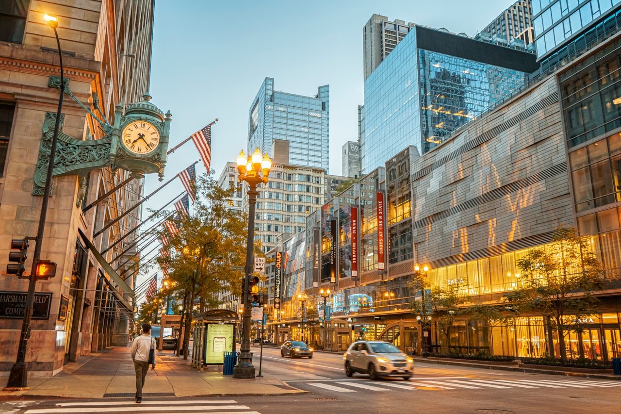 Vibrant city street in downtown Chicago with illuminated buildings and pedestrians.